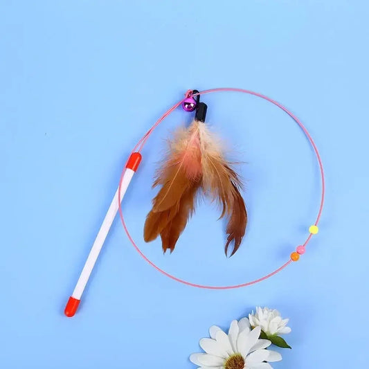 Cat feather teaser wand toy with bell and beads on blue background, flower decor
