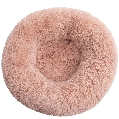 Plush round pink pet bed with raised rim and shaggy faux fur texture, ideal for dogs or cats